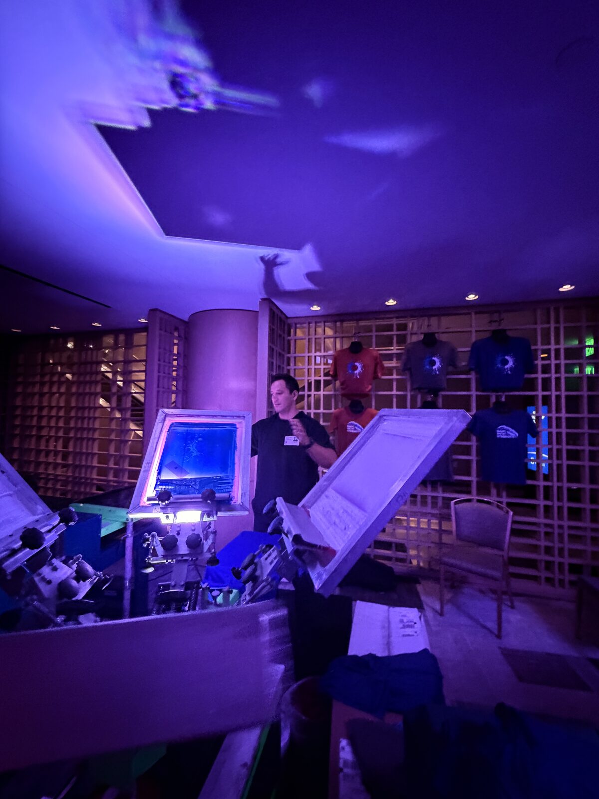 Press station glowing under purple uplighting at a late night event
