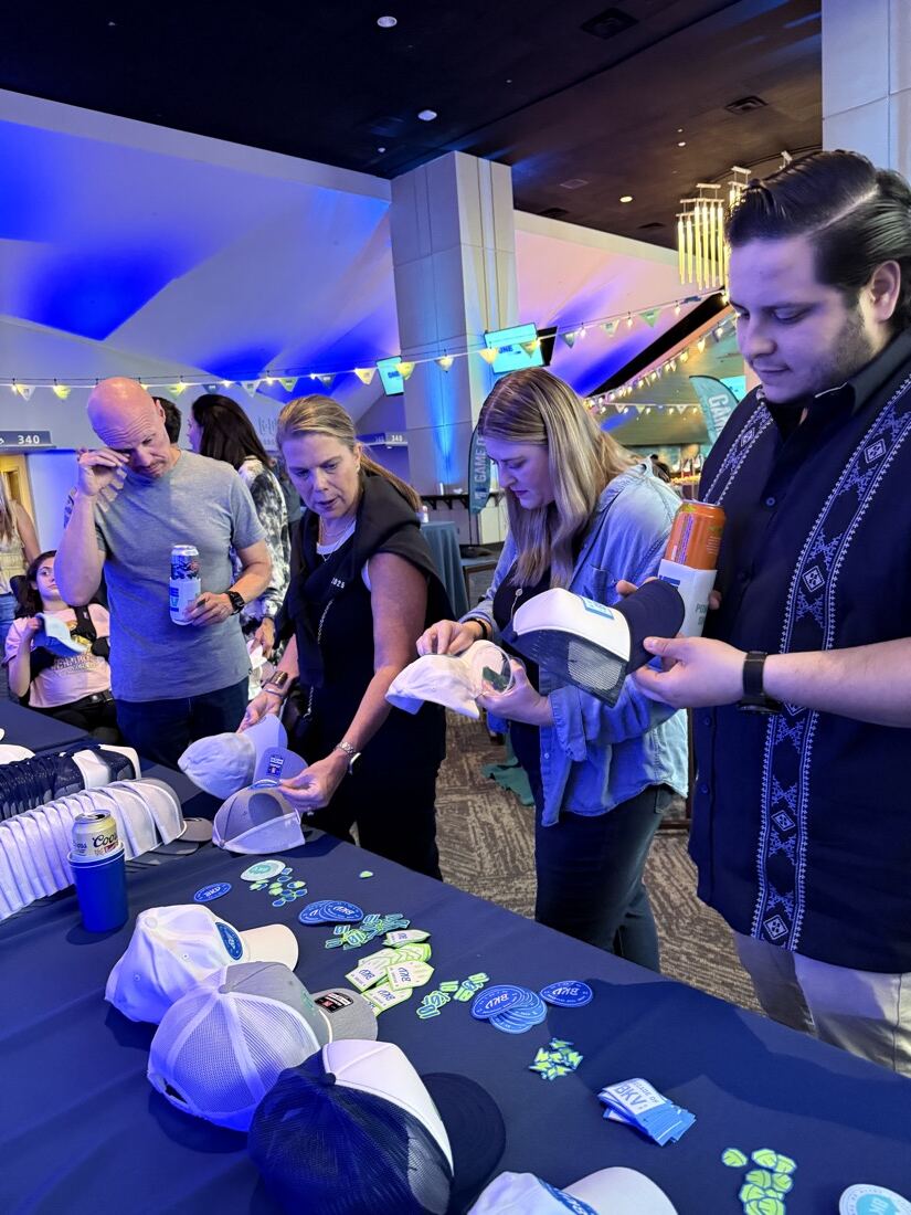 Guests picking hats and patches from a personalization table at an evening reception