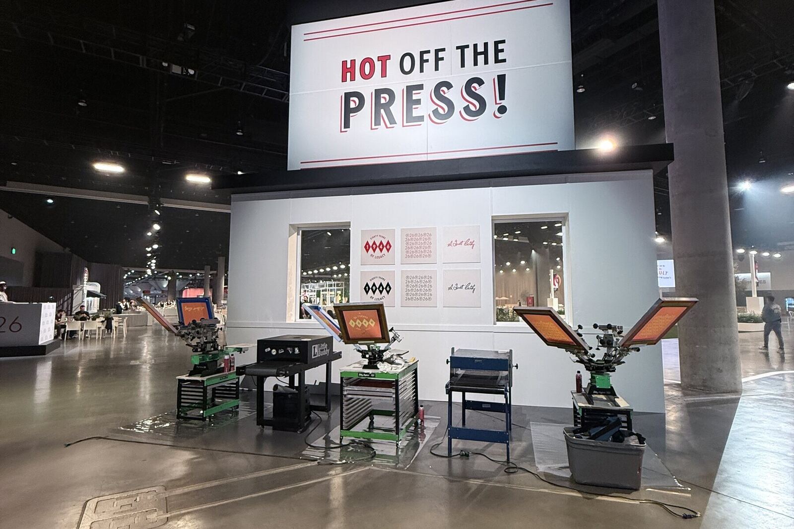 Hot Off The Press booth with multiple printing stations built out on an event floor